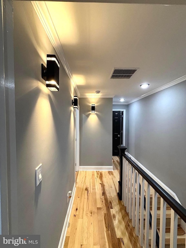 corridor featuring crown molding and light hardwood / wood-style flooring