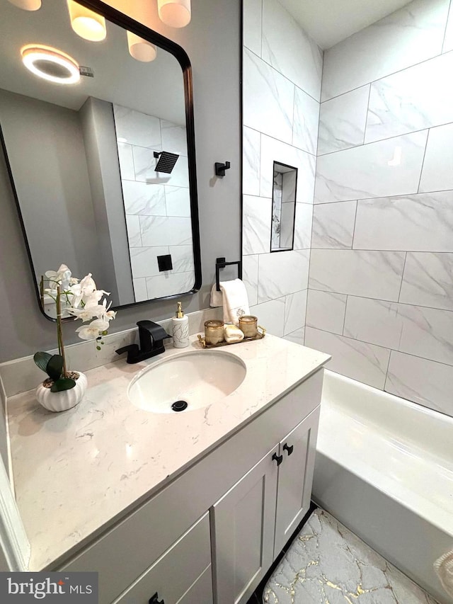 bathroom featuring vanity and tiled shower / bath