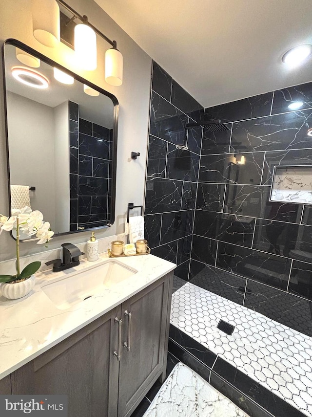 bathroom featuring vanity and tiled shower