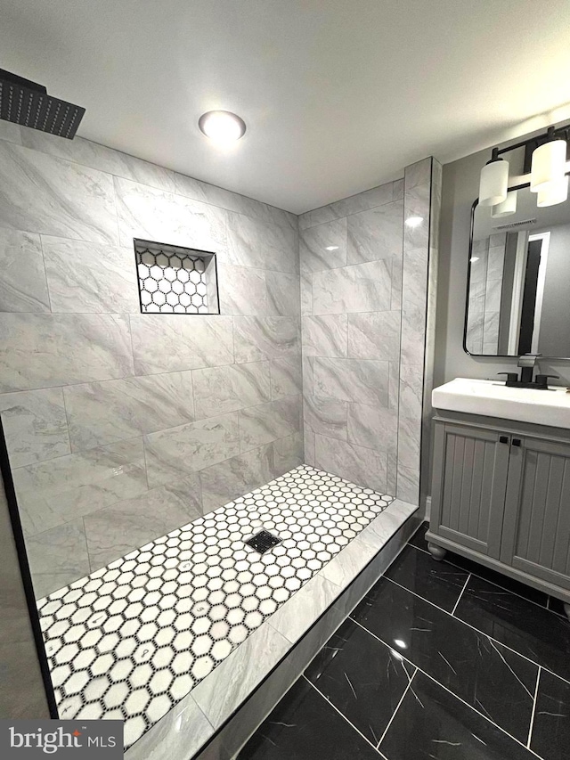 bathroom featuring tiled shower and vanity