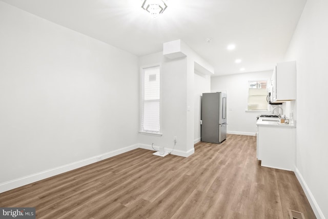 unfurnished living room with light hardwood / wood-style floors and sink