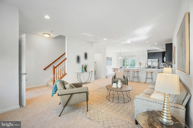 living room with light colored carpet and sink