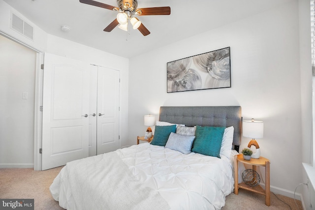 carpeted bedroom featuring ceiling fan and a closet