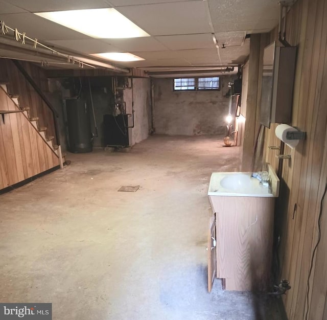 basement with wood walls and water heater