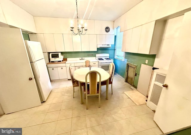 kitchen with white cabinetry, an inviting chandelier, range hood, decorative light fixtures, and white appliances