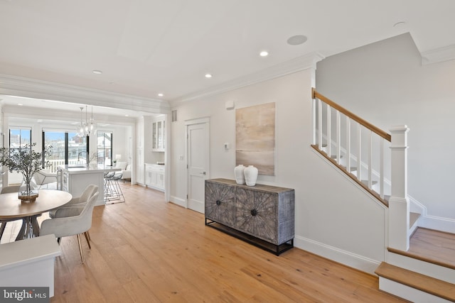 unfurnished dining area featuring ornamental molding, stairway, light wood-type flooring, and baseboards