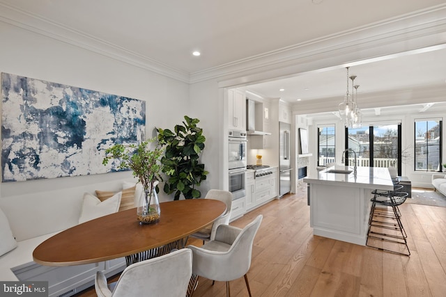 dining space featuring a chandelier, recessed lighting, light wood-style flooring, and crown molding