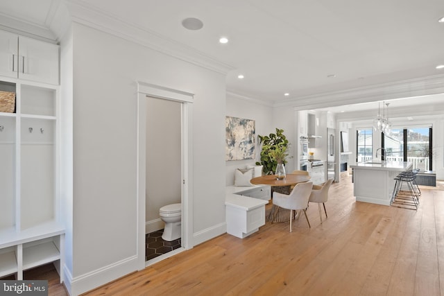 dining room with ornamental molding, recessed lighting, light wood-style flooring, and baseboards