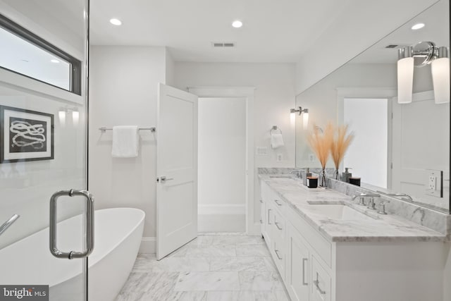 full bath with visible vents, marble finish floor, a freestanding tub, a sink, and recessed lighting