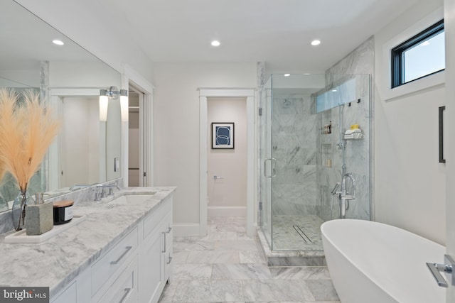 bathroom featuring baseboards, marble finish floor, vanity, a freestanding tub, and recessed lighting