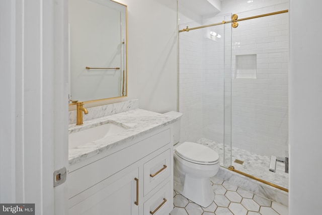 bathroom featuring toilet, a stall shower, and vanity