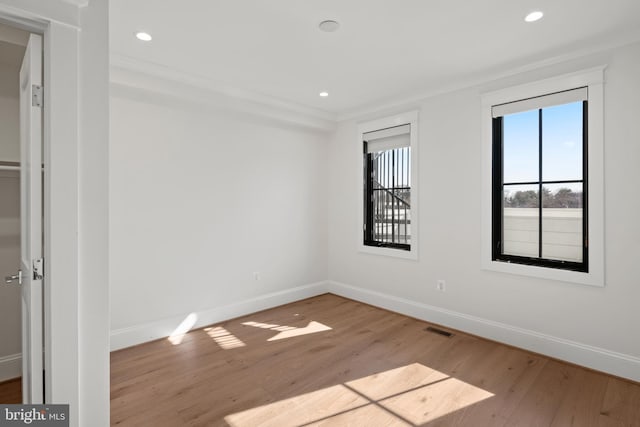 spare room with light wood finished floors, baseboards, and recessed lighting