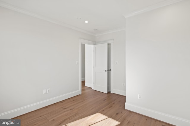 empty room with ornamental molding, recessed lighting, light wood-style flooring, and baseboards