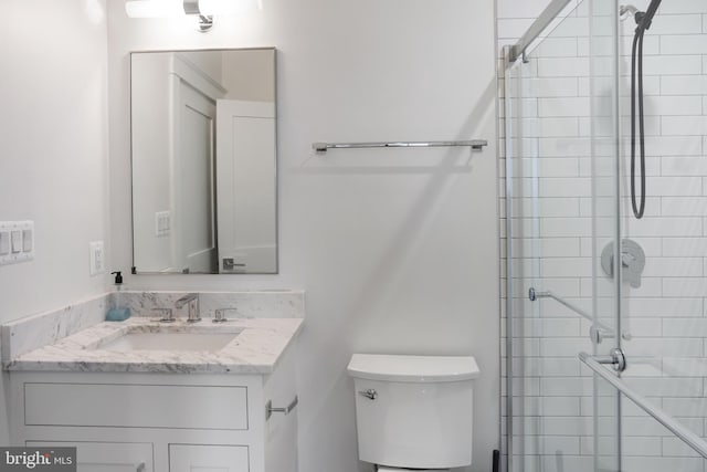 full bathroom featuring toilet, a tile shower, and vanity