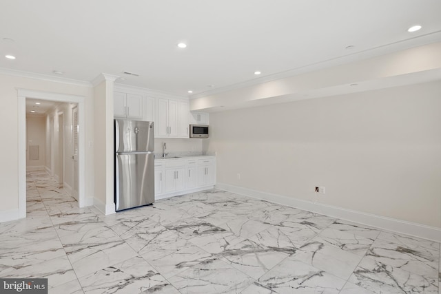 kitchen with appliances with stainless steel finishes, light countertops, white cabinets, and a sink