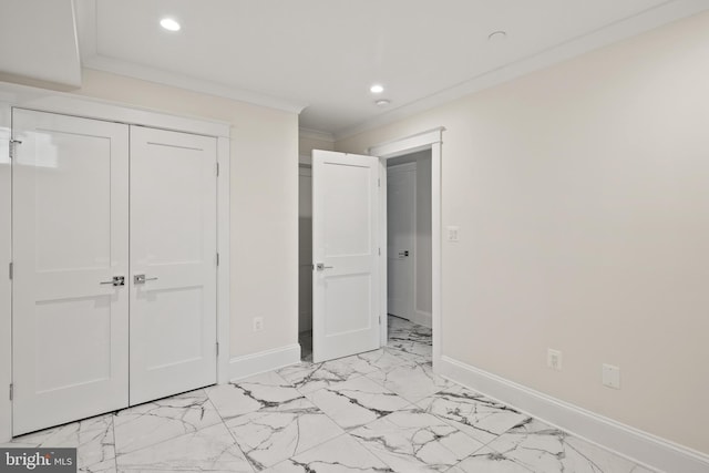 unfurnished bedroom with a closet, marble finish floor, and baseboards