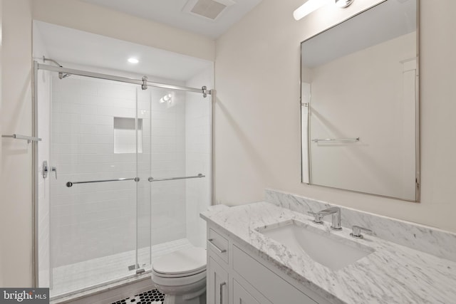 bathroom featuring a shower stall, visible vents, vanity, and toilet