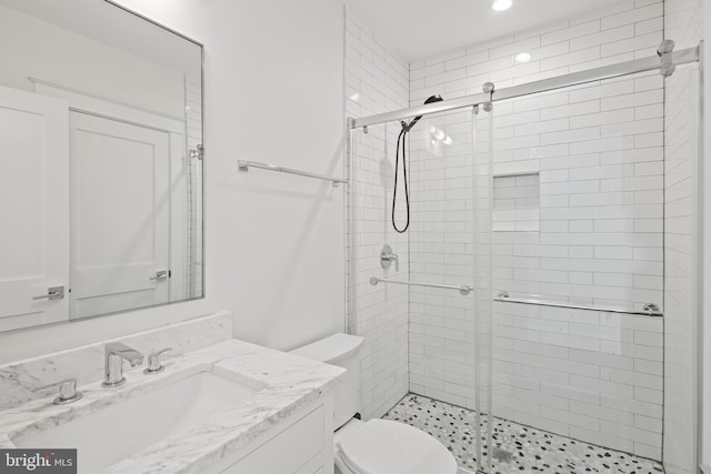 bathroom featuring toilet, a shower stall, recessed lighting, and vanity