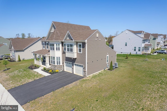 view of front of home featuring a residential view, driveway, central AC, a garage, and a front yard