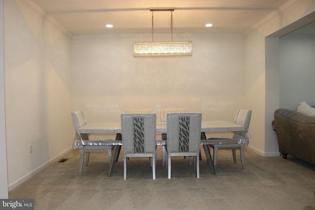 carpeted dining area with ornamental molding