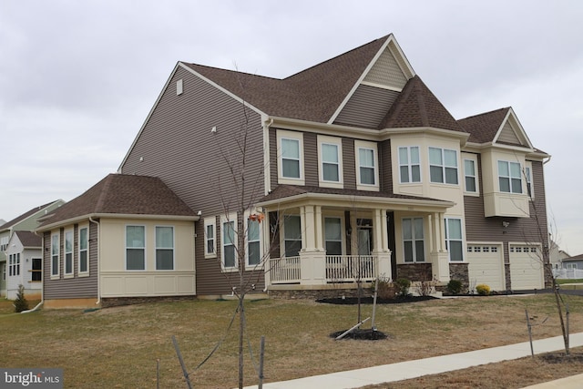 view of front facade with a porch, a garage, and a front lawn