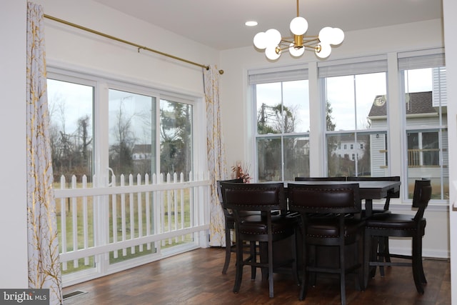 dining space featuring dark hardwood / wood-style floors and a notable chandelier