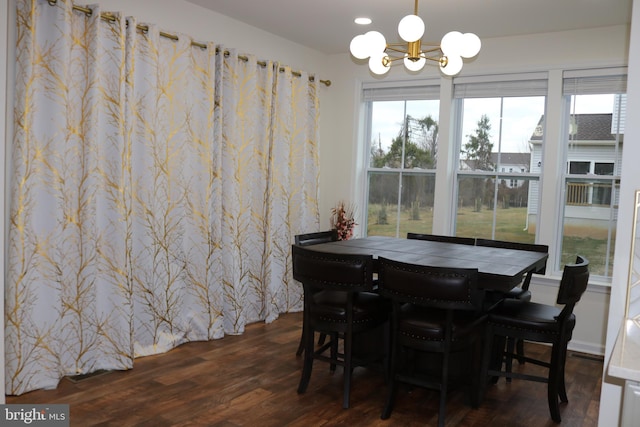 dining space featuring dark wood-type flooring, plenty of natural light, and a notable chandelier