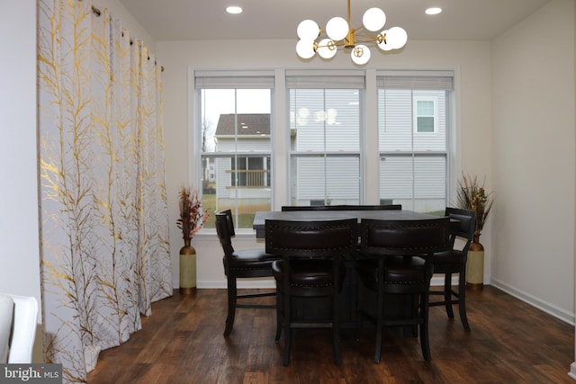 dining room with dark hardwood / wood-style flooring and an inviting chandelier