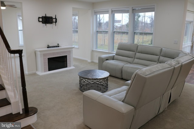 carpeted living room with ceiling fan