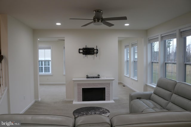 living room with a wealth of natural light, light colored carpet, and ceiling fan