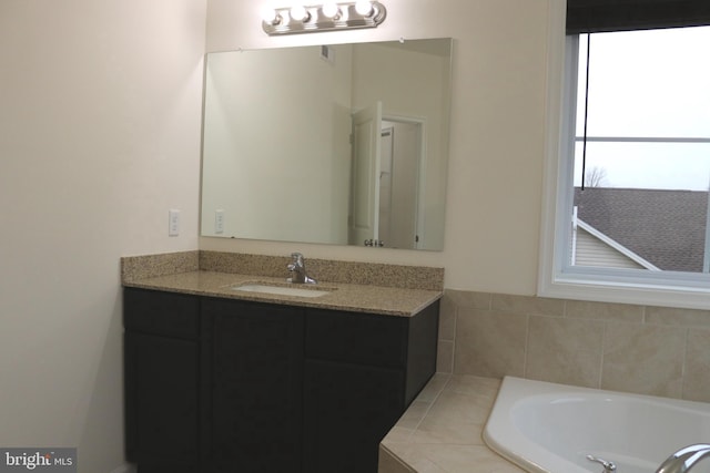 bathroom featuring vanity and tiled bath