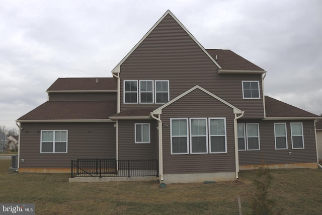 rear view of house with a yard and cooling unit