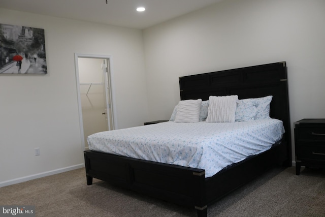 carpeted bedroom with a walk in closet and a closet