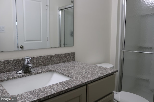 bathroom with vanity, toilet, and an enclosed shower