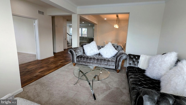 living room with dark hardwood / wood-style floors, ornamental molding, and an inviting chandelier