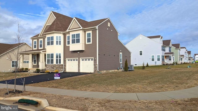 view of front facade with central air condition unit, a front lawn, and a garage