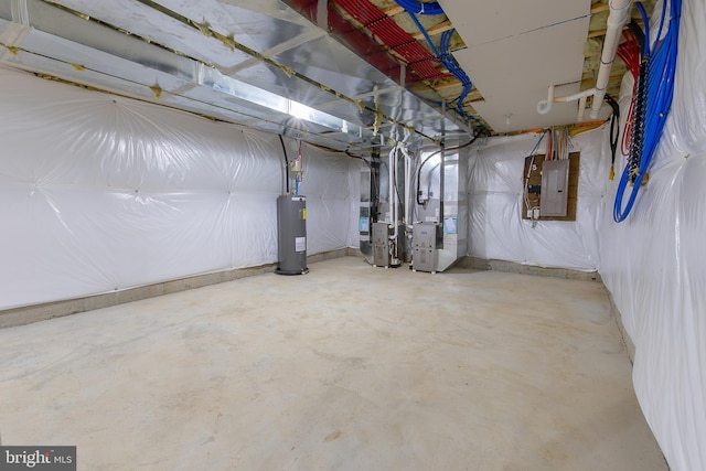 unfinished below grade area featuring electric panel, heating unit, and electric water heater