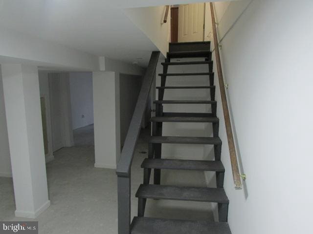 stairway featuring concrete floors