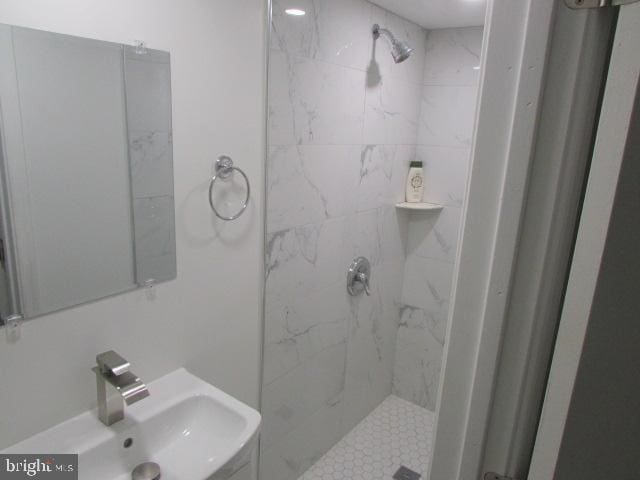 bathroom with a tile shower and sink