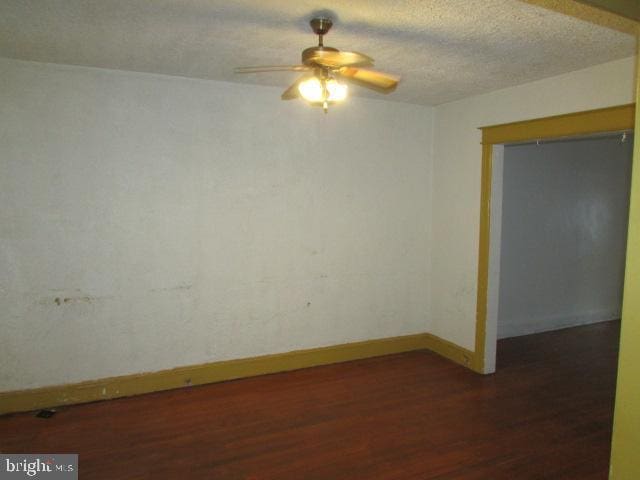 spare room with dark hardwood / wood-style flooring and ceiling fan