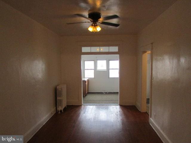 unfurnished room with ceiling fan, radiator heating unit, and hardwood / wood-style floors