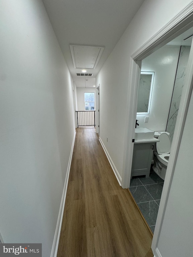 hallway with hardwood / wood-style floors and sink