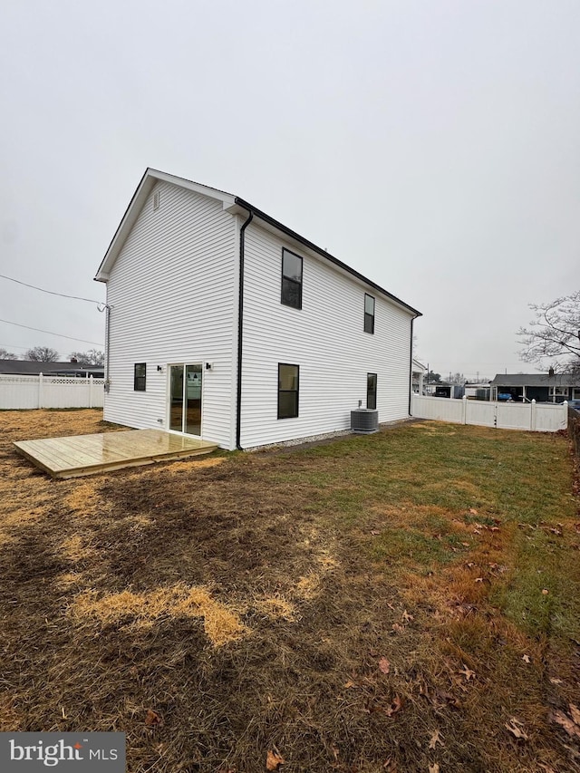 rear view of house featuring a patio, central air condition unit, and a lawn