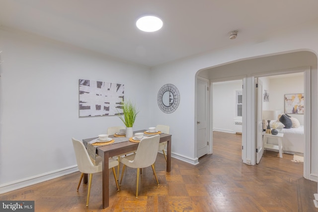 dining space featuring dark parquet floors