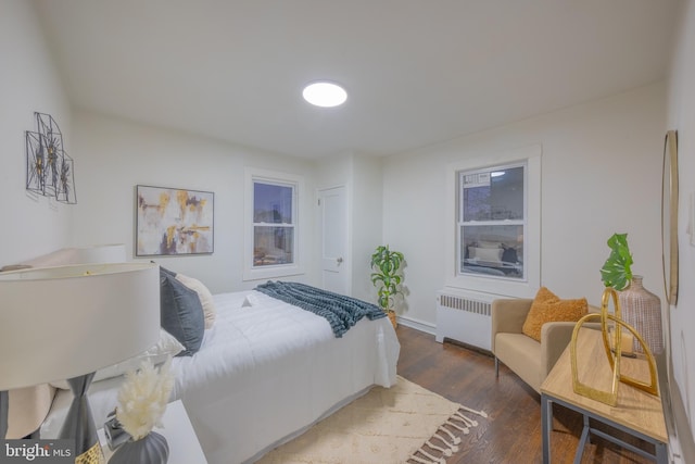 bedroom with radiator and dark wood-type flooring