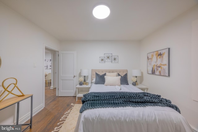 bedroom with dark hardwood / wood-style flooring