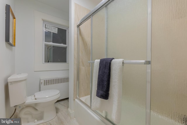 bathroom with toilet, combined bath / shower with glass door, and radiator heating unit