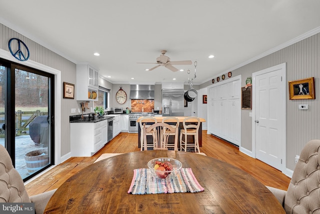 dining room with ceiling fan, light wood-type flooring, and ornamental molding