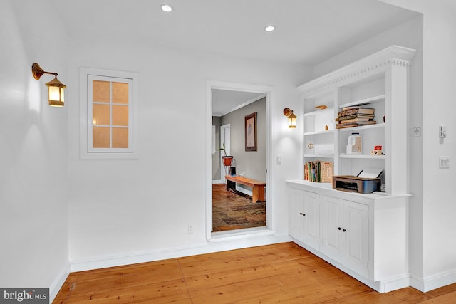 hallway featuring built in features and light wood-type flooring