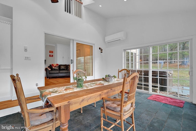 dining room with a wall mounted air conditioner and high vaulted ceiling